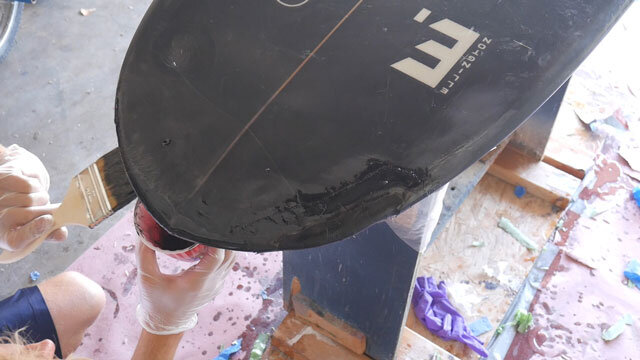 Painting resin on surfboard